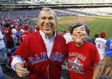 Texas Rangers fans wearing George W. and Laura Bush masks wait for the start of Game 4 of MLB's World Series between the Rangers and the Giants in Arlington, Texas